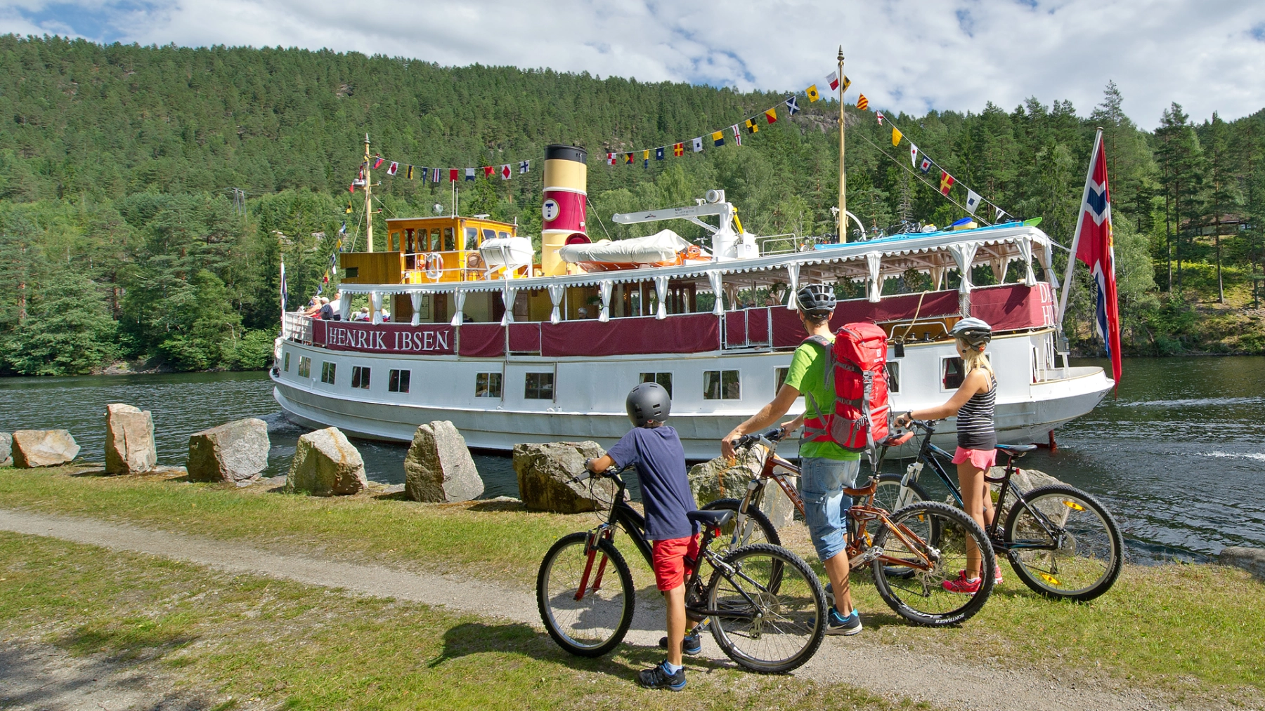Cykling vid Telemarkskanalen intill kanalbåten Henrik Ibsen. Foto: Kåre Pedersen