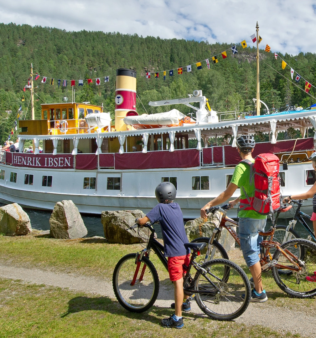 Cykling vid Telemarkskanalen intill kanalbåten Henrik Ibsen. Foto: Kåre Pedersen