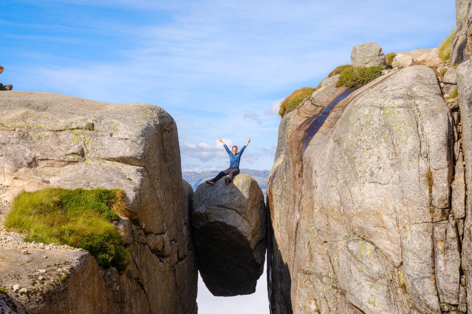 Woman sitting on the Kjerag boulder. Foto: Sven-Erik Knoff, FotoKnoff, Region Stavanger.ion Stavanger