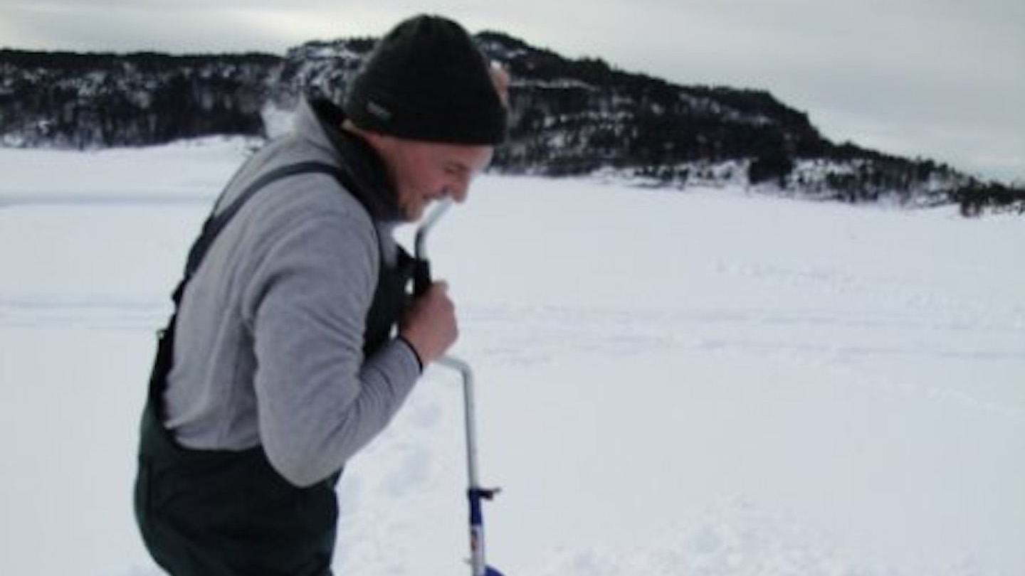 Isfiskare g&ouml;r h&aring;l i isen. Foto: Anneriek Barree